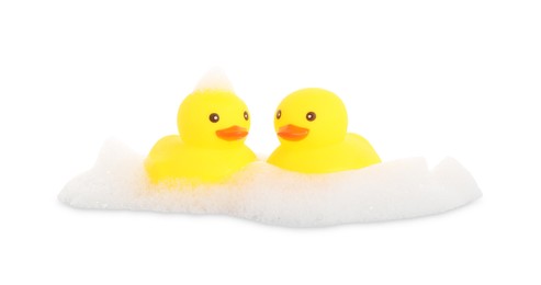 Photo of Cute rubber ducks and foam isolated on white