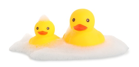 Photo of Cute rubber ducks and foam isolated on white