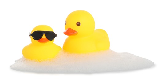 Photo of Cute rubber ducks and foam isolated on white
