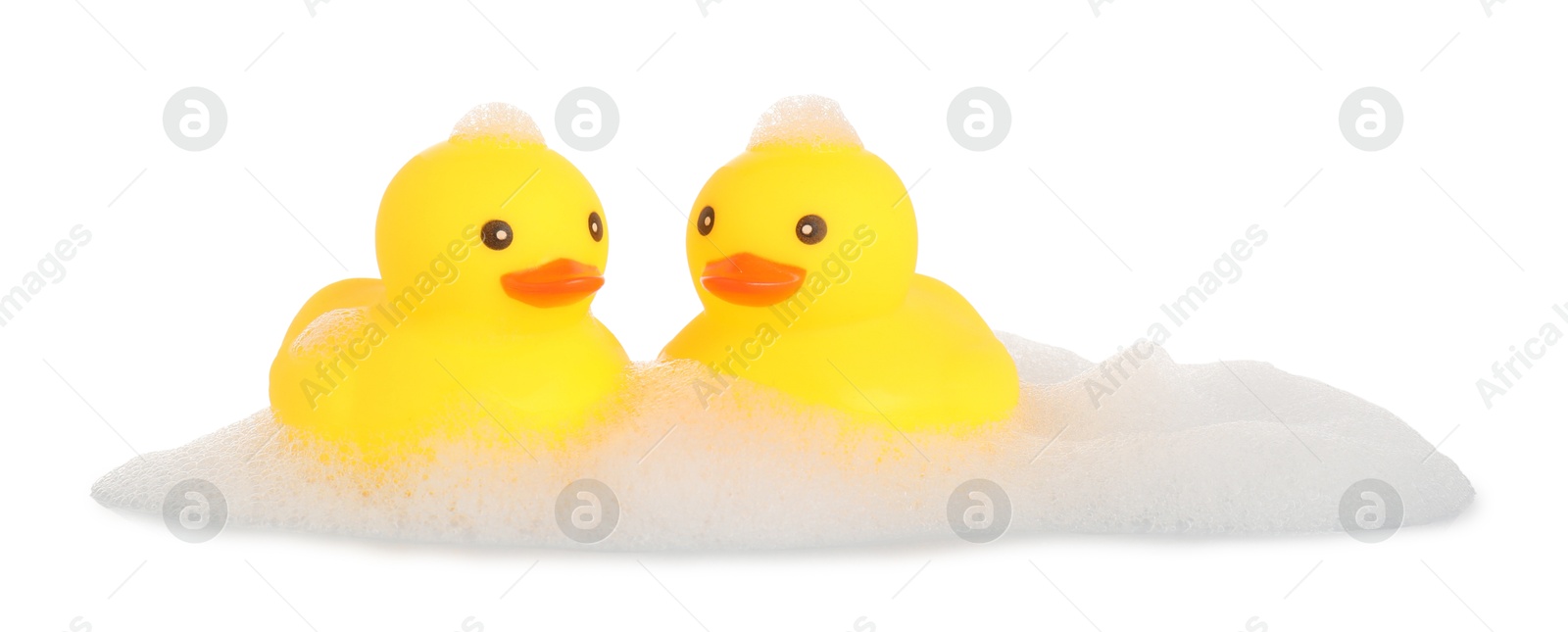 Cute rubber ducks and foam isolated on white Photo of Cute rubber ducks and foam isolated on white