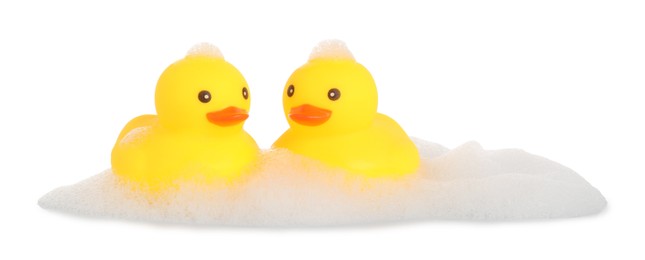 Photo of Cute rubber ducks and foam isolated on white