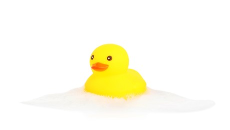 Photo of One cute rubber duck and foam isolated on white