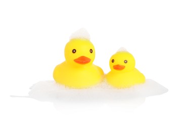 Photo of Cute rubber ducks and foam on mirror surface against white background