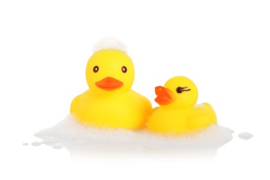Photo of Cute rubber ducks and foam on mirror surface against white background