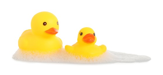 Photo of Cute rubber ducks and foam on mirror surface against white background
