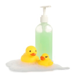 Photo of Cute rubber ducks, bottle of bath products and foam isolated on white