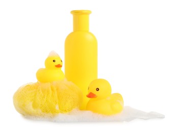 Photo of Cute rubber ducks, bottle of bath product, shower puff and foam isolated on white
