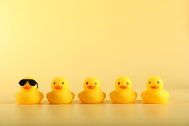 Photo of Many cute rubber ducks on yellow background