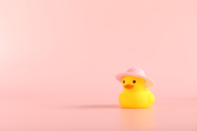 Photo of Cute rubber duck in hat on pink background, space for text