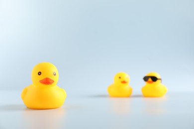 Photo of Three cute rubber ducks on white background