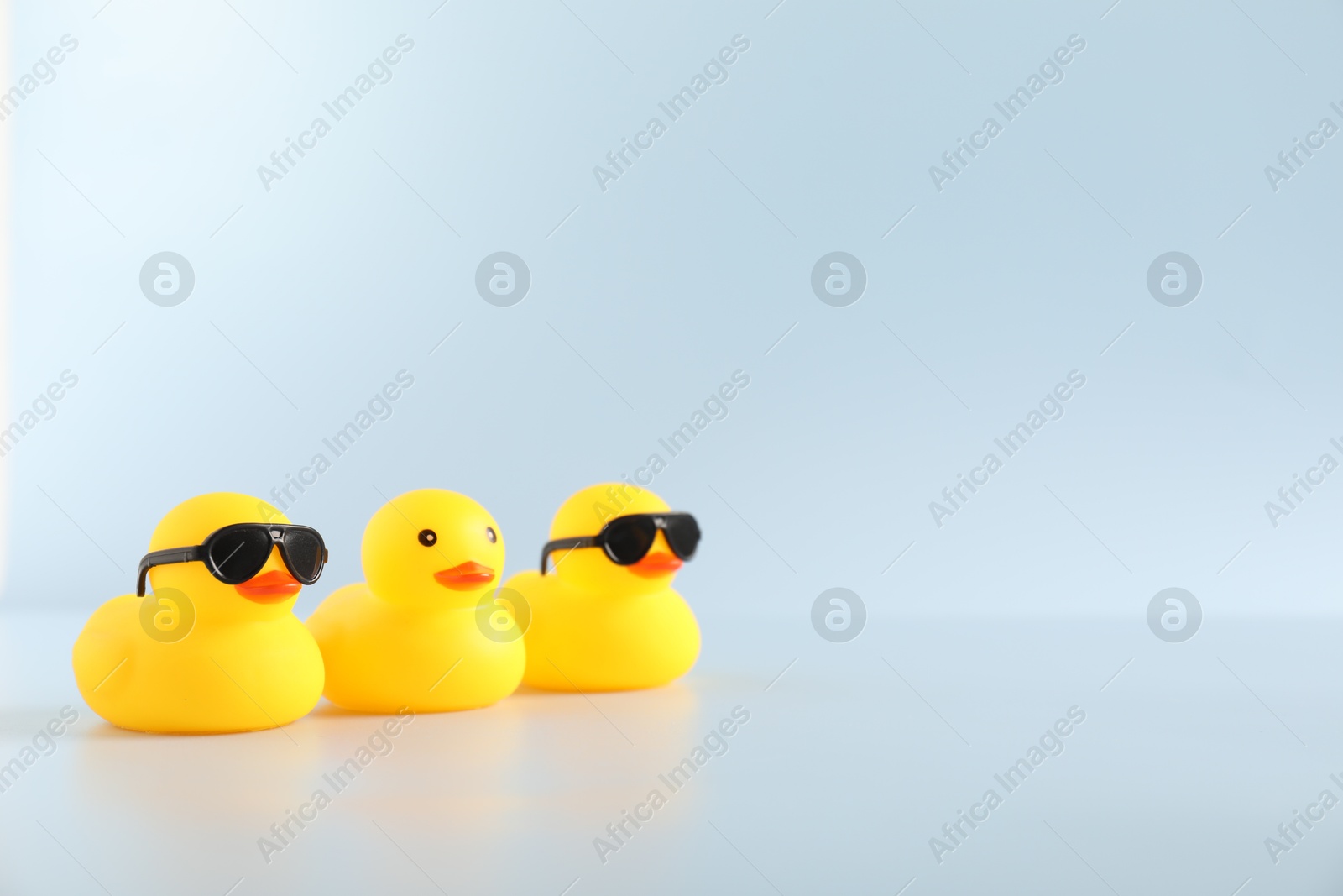 Three cute rubber ducks on white background, space for text Photo of Three cute rubber ducks on white background, space for text