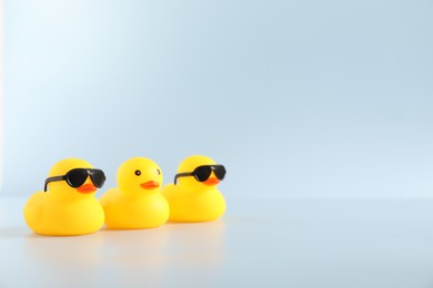 Photo of Three cute rubber ducks on white background, space for text