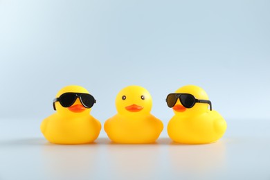 Photo of Three cute rubber ducks on white background