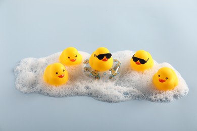 Photo of Cute rubber ducks, foam and inflatable ring on white background, above view