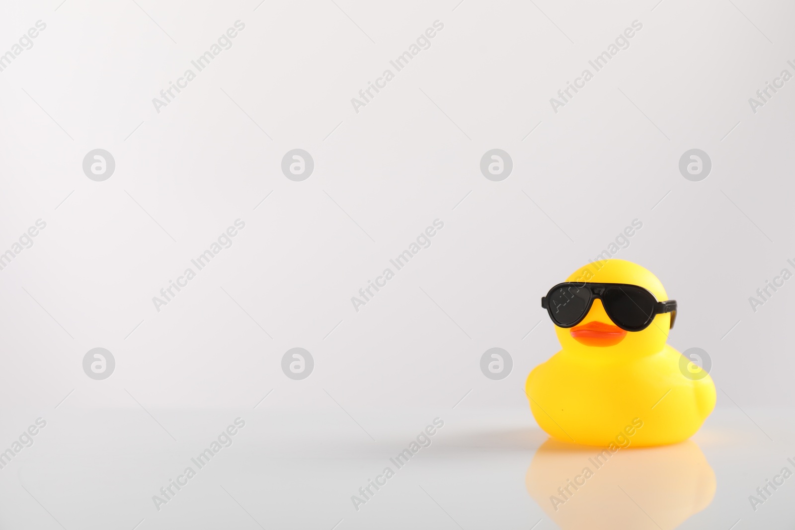 Cute rubber duck in sunglasses on white background, space for text Photo of Cute rubber duck in sunglasses on white background, space for text