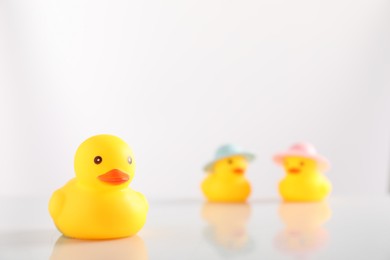 Photo of Cute rubber ducks on white background, selective focus. Space for text