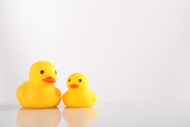 Photo of Cute rubber ducks on white background, space for text