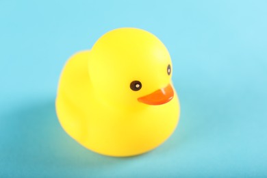 Photo of One cute rubber duck on light blue background, closeup