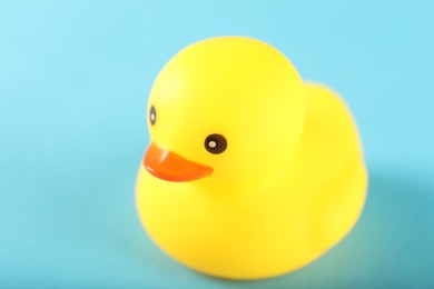 Photo of One cute rubber duck on light blue background, closeup. Space for text