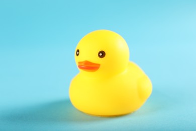 Photo of One cute rubber duck on light blue background, closeup