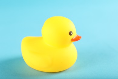Photo of One cute rubber duck on light blue background, closeup