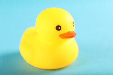 Photo of One cute rubber duck on light blue background, closeup