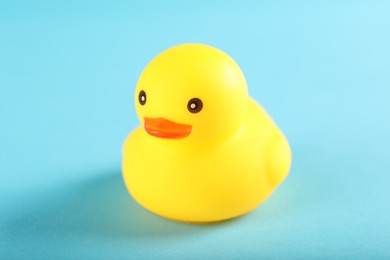 Photo of One cute rubber duck on light blue background, closeup