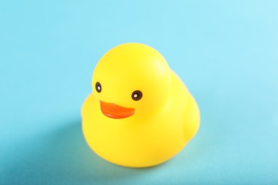 Photo of One cute rubber duck on light blue background, closeup