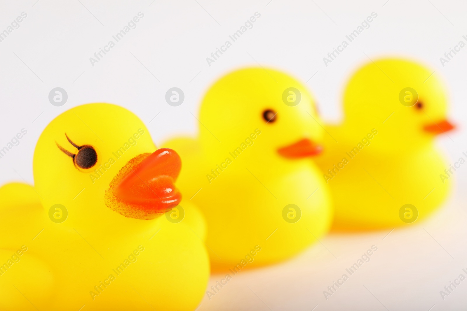 Three cute rubber ducks on white background, closeup. Space for text Photo of Three cute rubber ducks on white background, closeup. Space for text