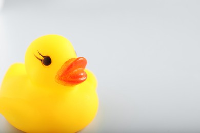 Photo of One cute rubber duck on white background, closeup. Space for text