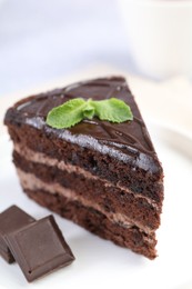Photo of Piece of delicious cake, mint and chocolate on light table, closeup