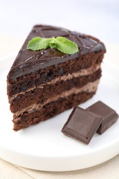 Photo of Piece of delicious cake, mint and chocolate on light table, closeup