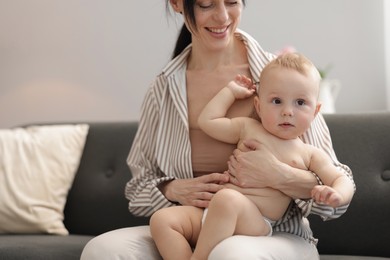 Photo of Smiling mother with her little baby on sofa indoors