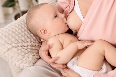 Photo of Mother breastfeeding her little baby indoors, closeup