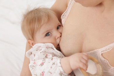 Photo of Mother breastfeeding her cute little baby on bed, closeup