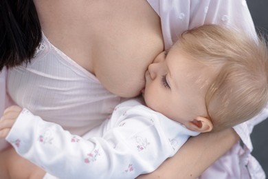 Photo of Mother breastfeeding her cute little baby, closeup
