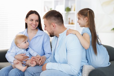 Photo of Happy parents and their kids together on sofa at home