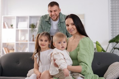 Photo of Happy parents and their kids together at home