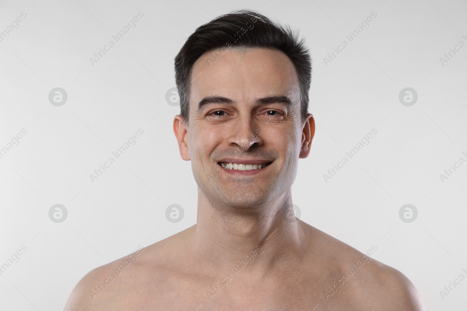 Portrait of smiling man on light grey background, closeup Photo of Portrait of smiling man on light grey background, closeup