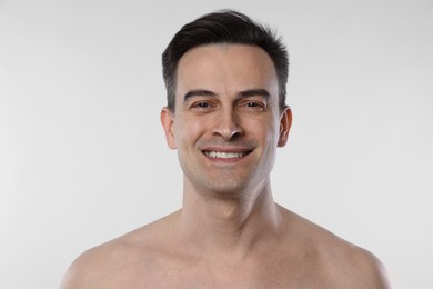 Photo of Portrait of smiling man on light grey background, closeup