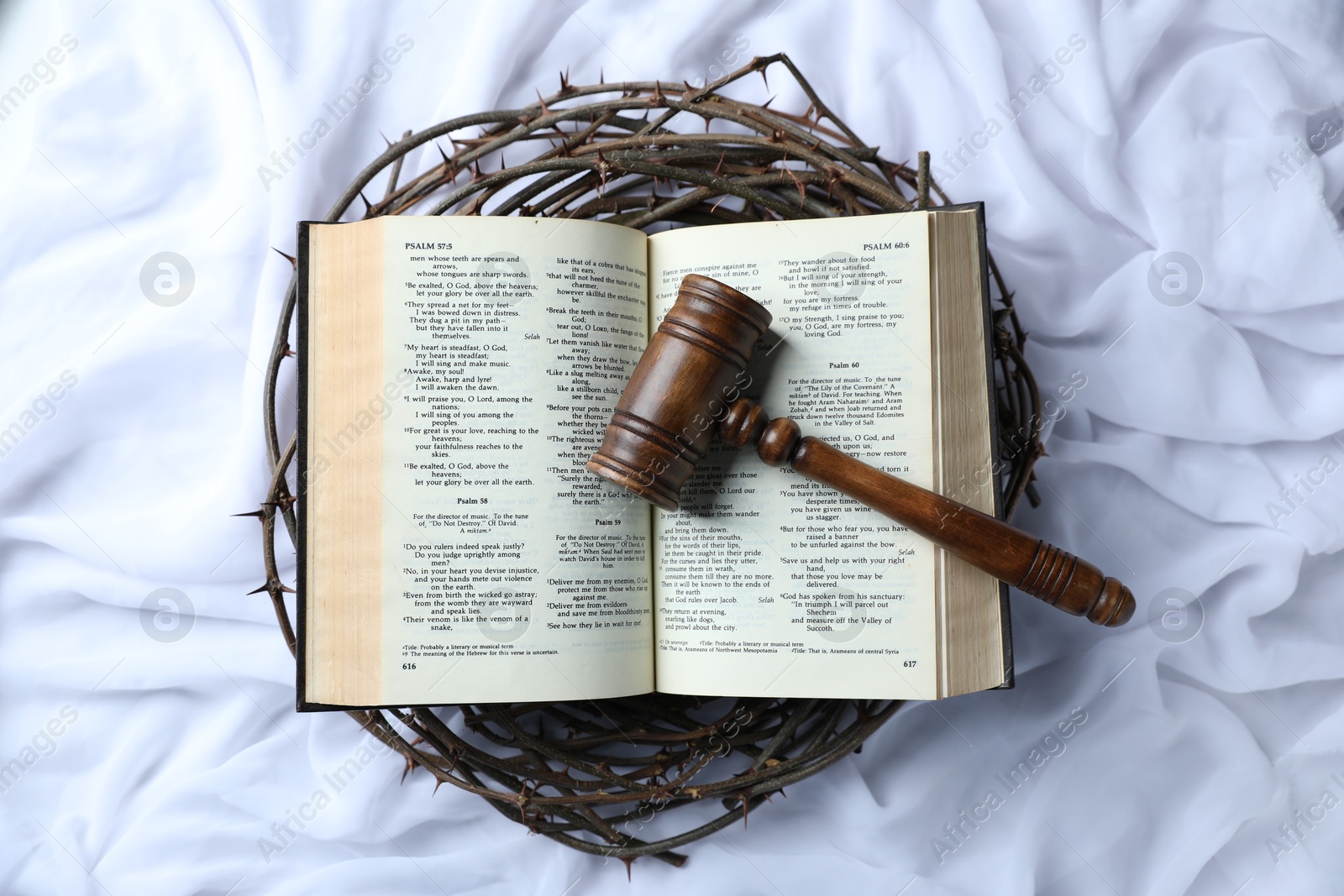 Judge's gavel, crown of thorns and Bible on white fabric, top view Photo of Judge's gavel, crown of thorns and Bible on white fabric, top view