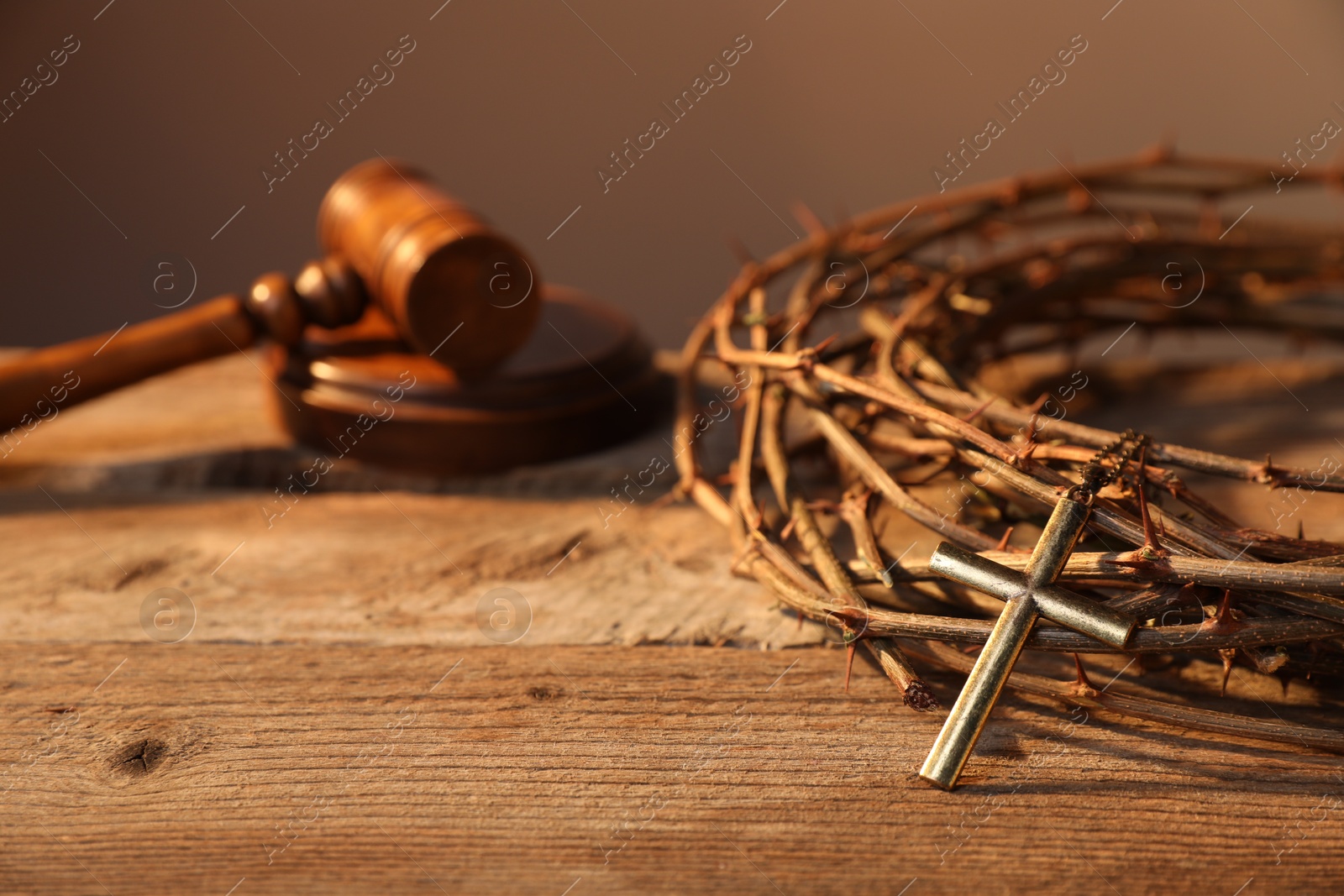 Crown of thorns with cross and judge's gavel on wooden table, closeup Photo of Crown of thorns with cross and judge's gavel on wooden table, closeup