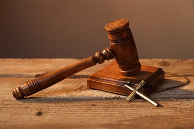 Photo of Judge's gavel and cross on wooden table