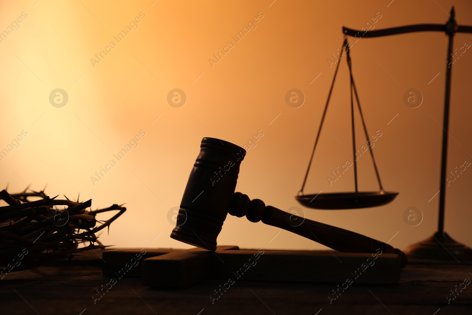 Judge's gavel, crown of thorns and scales on wooden table against pale orange gradient background, closeup Photo of Judge's gavel, crown of thorns and scales on wooden table against pale orange gradient background, closeup