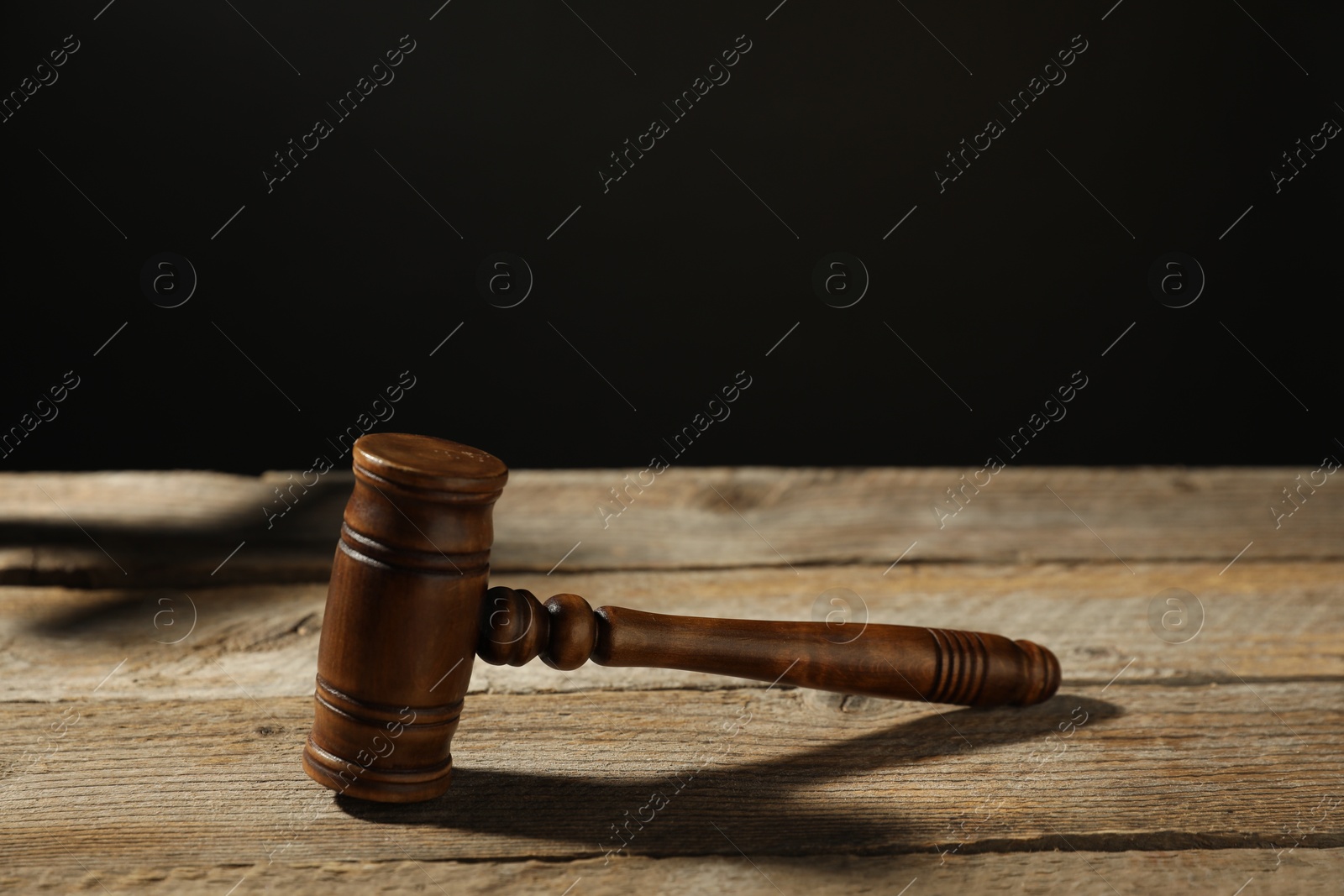 Judge's gavel on wooden table against black background Photo of Judge's gavel on wooden table against black background
