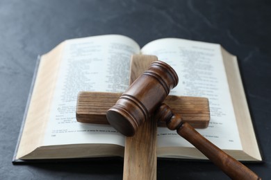 Photo of Judge's gavel, Bible and wooden cross on black table, above view