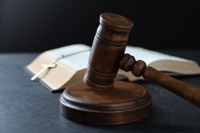 Photo of Judge's gavel, Bible and cross on black table, closeup