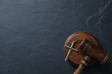 Photo of Judge's gavel and cross on black table, top view. Space for text