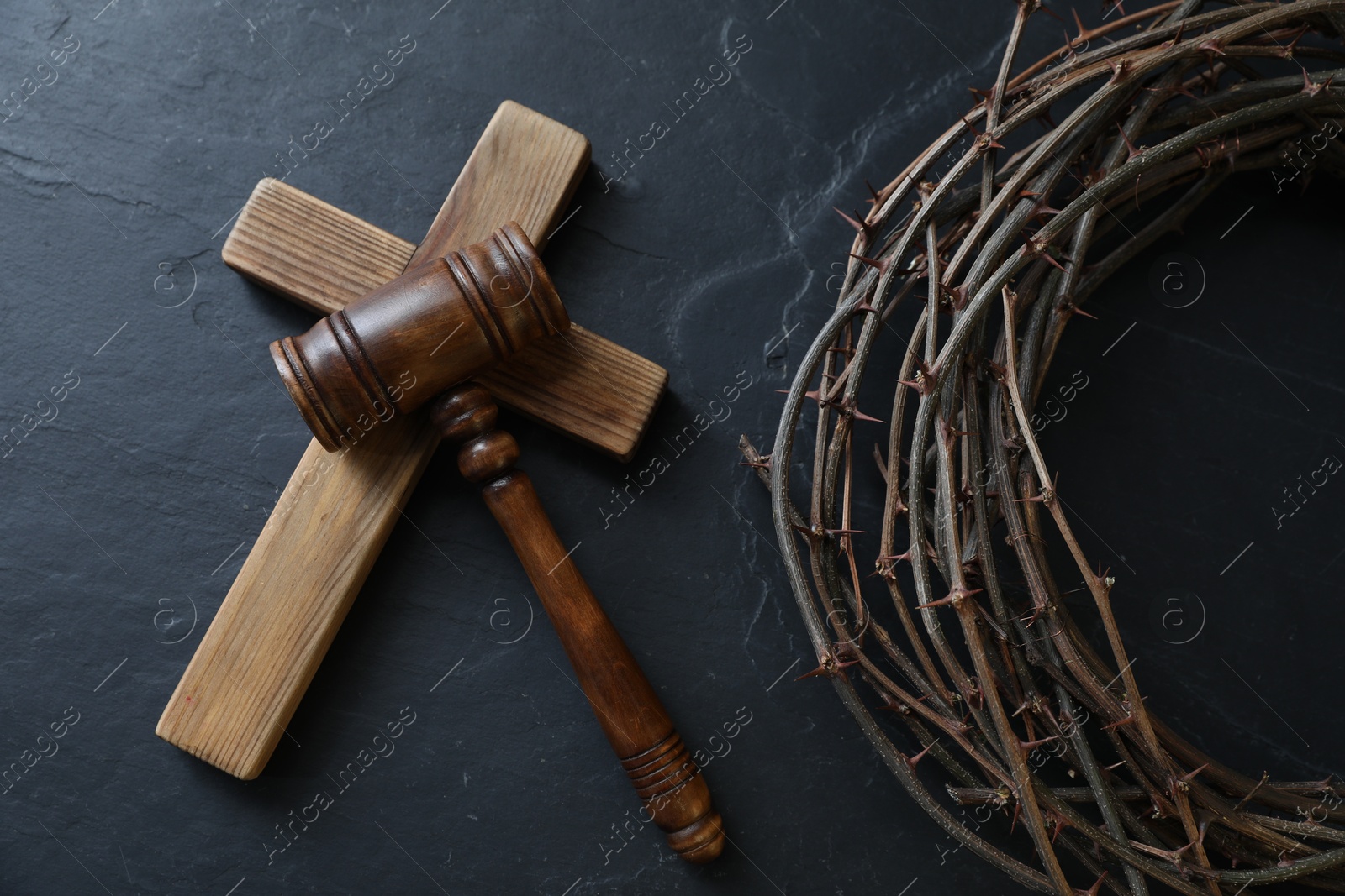 Judge's gavel, crown of thorns and wooden cross on black table, flat lay Photo of Judge's gavel, crown of thorns and wooden cross on black table, flat lay