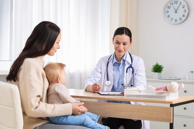 Photo of Mother and her cute baby having appointment with pediatrician in clinic